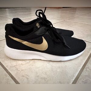 Girls Nike athletic shoes size 6.5 Y. Black with gold swoosh.